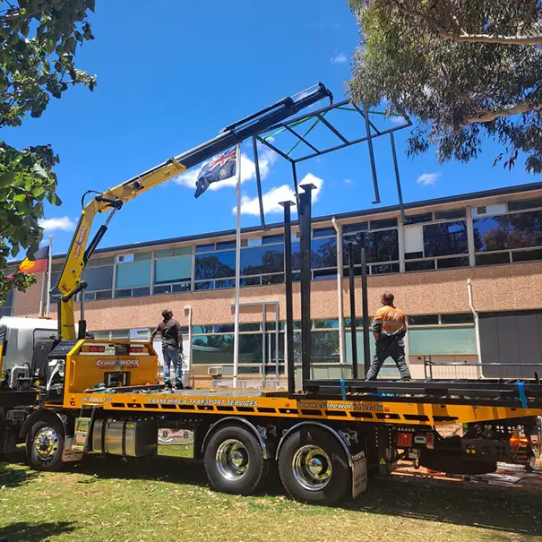 Two traders on top of a truck loading construction frames